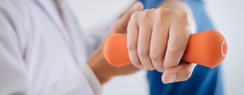 Doctor physiotherapist assisting a male patient while giving exe